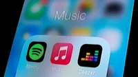 In this photo illustration, a Spotify app, Apple Music app and Deezer app are seen displayed on a smartphone.