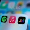 In this photo illustration, a Spotify app, Apple Music app and Deezer app are seen displayed on a smartphone.